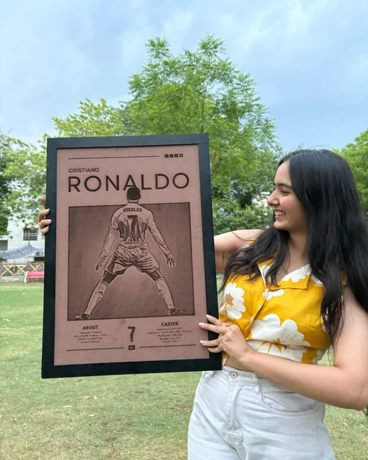 A person holding a framed poster of Cristiano Ronaldo, with the frame depicting an illustration of Ronaldo in a soccer uniform with the number 7 on it.