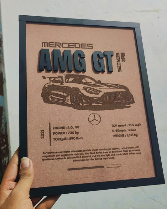 Plaque with Mercedes-AMG GT design held by a hand against a blurred background